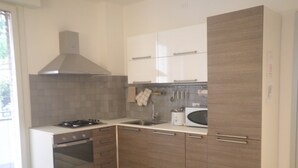 Eine moderne Küche mit Gasherd, Backofen, Mikrowelle und Holzschränken.