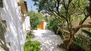 A pathway leading to a building with a white exterior and a wooden door. - Private Grounds, Walking Distance to Puerto Pollensa, New PS5, Bikes (Puerto Pollensa)
