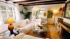 A living room with white furniture, a glass coffee table, a fireplace, and a view of the outdoors. - Private Grounds, Walking Distance to Puerto Pollensa, New PS5, Bikes (Puerto Pollensa)