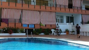 Ein mehrstöckiges Hotel mit Balkonen, einem Schwimmbecken und Außenbereich.