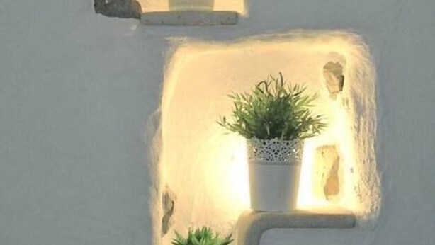 A wall with two built-in planters with plants.