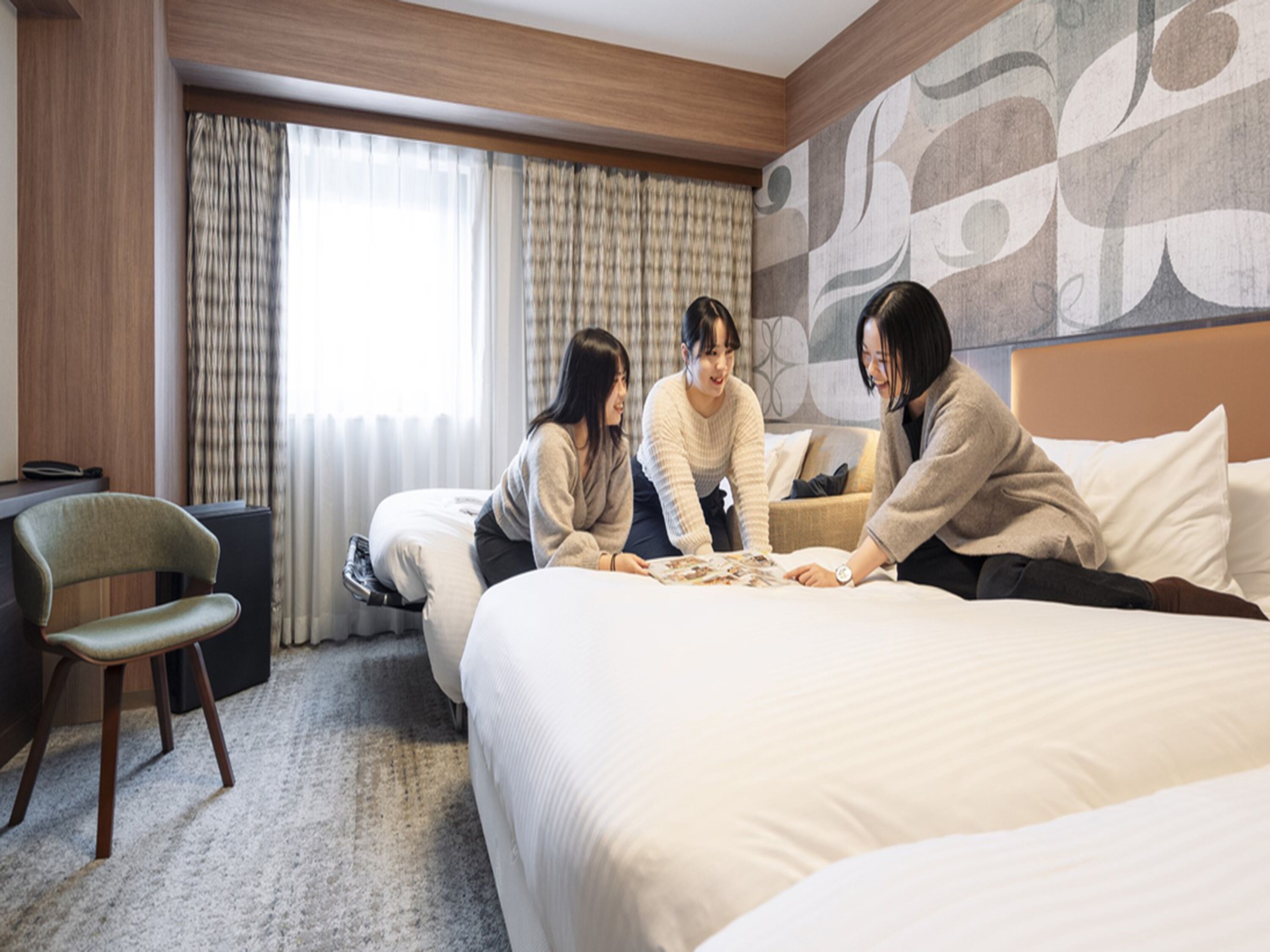 A hotel room with a large bed, a chair, and a desk.