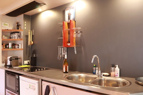 A modern kitchen with stainless steel appliances, a wine rack, and various kitchen utensils.