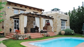 A stone house with a pool, outdoor seating, and a covered patio. - Rock House's Villa Rhapsody  (2 Bedrooms, Sleeps 4) with private garden and pool (Crete)