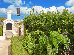 A stone building with a chimney, a metal gate, and a pathway. - Seaview Apts, 80 meters to beach, crystal clear sea, 2 apts, large terraces, BBQ (Rogoznica)