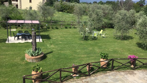 A well-maintained garden with a pergola, outdoor seating, and potted plants. - Holiday home in the Florentine Chianti area (Reggello)