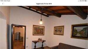 A room with wooden flooring, a brown sofa, and three framed paintings on the wall. - Holiday home in the Florentine Chianti area (Reggello)