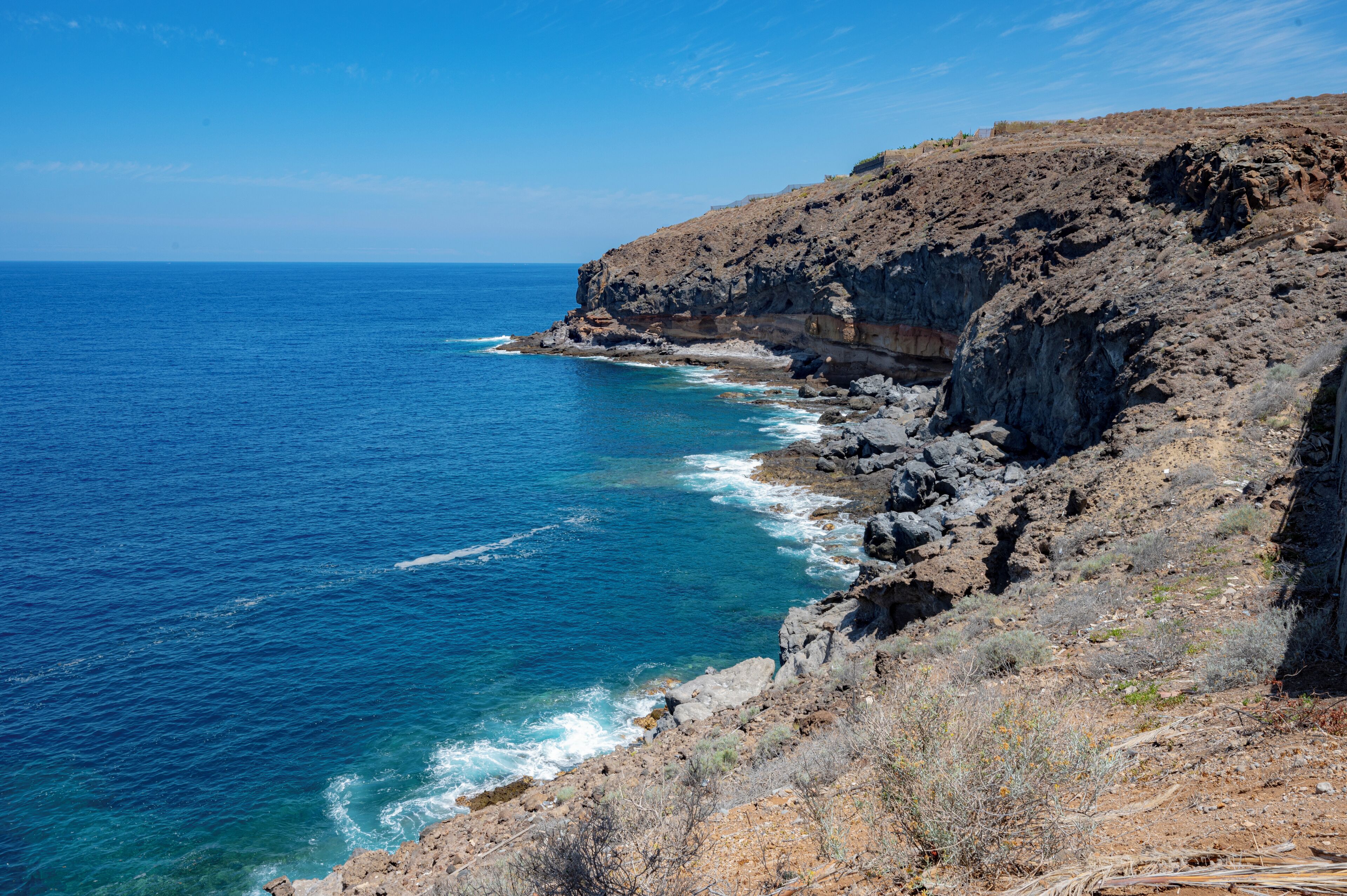 Een kustlandschap met rotsachtige kliffen en de zee.