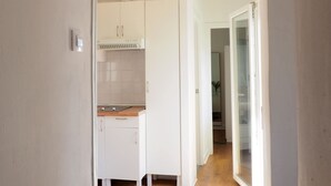 Eine moderne Küche mit weißen Schränken, einer Holz Arbeitsplatte und einem sichtbaren Abluftventilator.