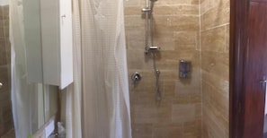 A bathroom with a shower, a toilet, and a sink.