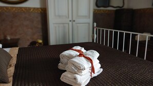 A neatly made bed with folded towels and a brown bedspread. - APARTMENT IN THE HISTORICAL CENTER OF CATANIA (CATANIA)