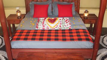 A bed with a checkered bedspread, red and grey pillows, and a heart-shaped decoration with 'Happy New Year' written on it.