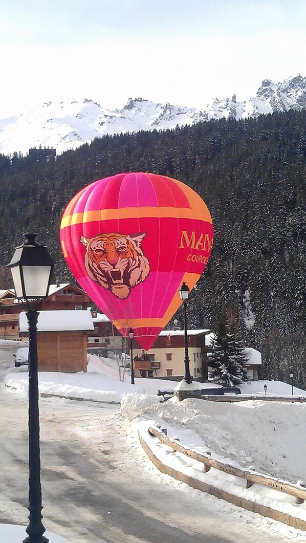 Une montgolfière décorée avec un motif de tigre est garée près d’un lampadaire.