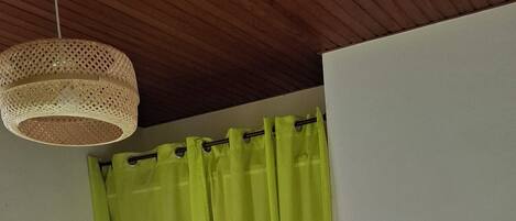 Una habitación con cama, una escalera y una cortina.