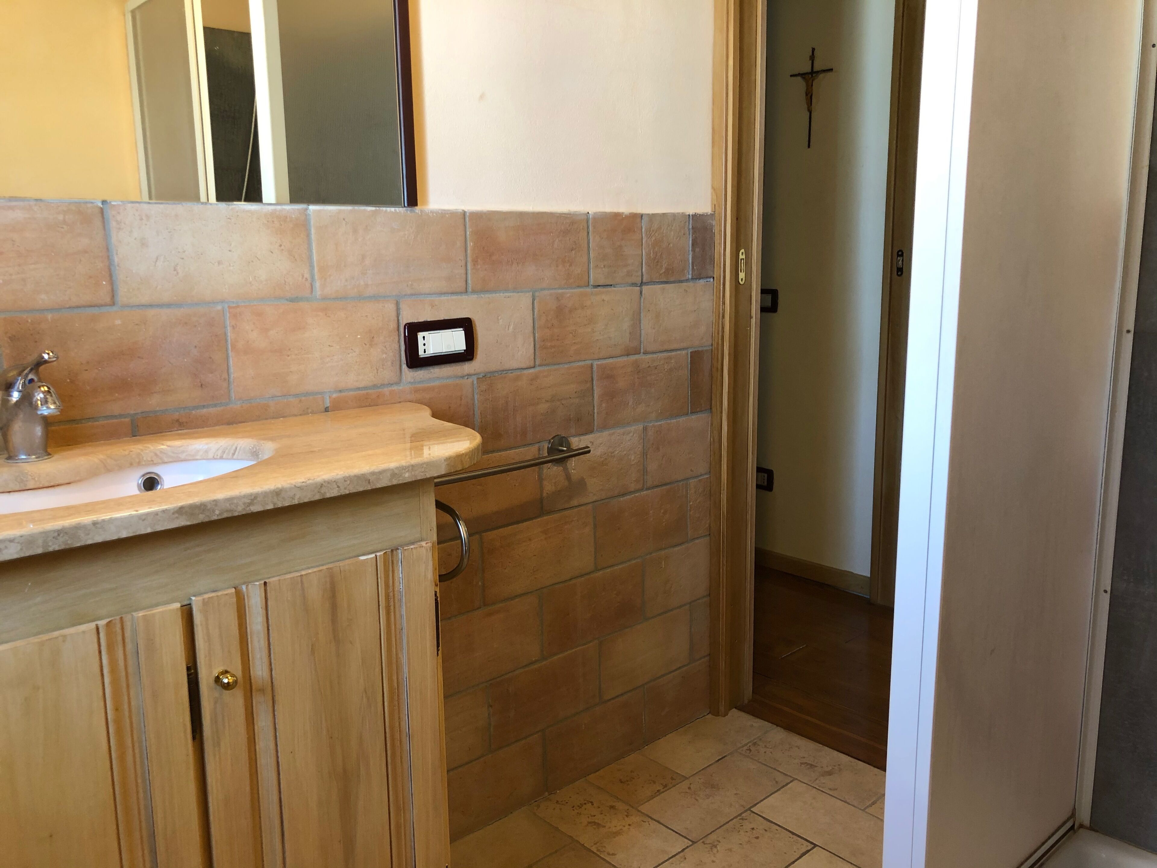 Une salle de bain avec un lavabo, un miroir et des murs carrelés.
