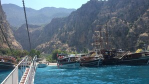 Un paysage côtier avec plusieurs bateaux amarrés près d’une région montagneuse.