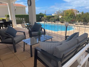 A terrace with outdoor furniture, a pool, and a view of the sea. - Large detached family Villa with private pool and beautiful gardens, full a/c. (Peyia)