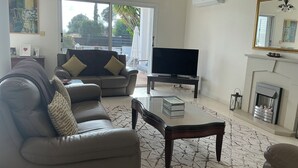 Ein Wohnzimmer mit einer Couch, einem Couchtisch, einem Fernseher und einem Kamin.