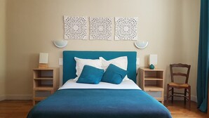 A neatly arranged bedroom with a bed, bedside tables, and a chair. - Villa with private pool in Carcassonne town, quiet area with castle views (Carcassonne)