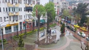 A multi-story building with a bank on the ground floor, a landscaped plaza with a statue, and parked cars. - Hakbilir Pansiyon (Amasra)