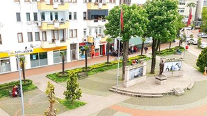 A public square with a central monument, surrounded by buildings and trees. - Hakbilir Pansiyon (Amasra)