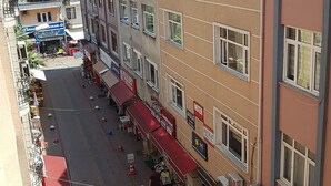 A street view with a row of shops and a building with multiple windows and balconies. - Hakbilir Pansiyon (Amasra)