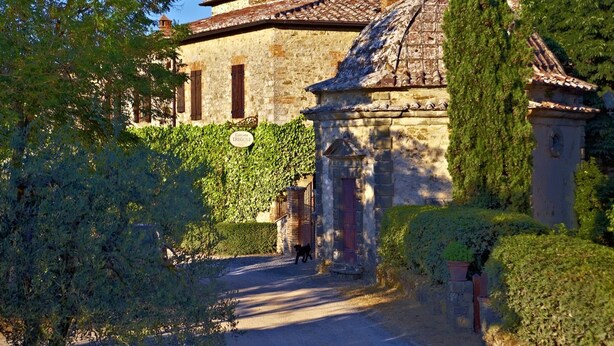 A stone building with a tiled roof, ivy-covered walls, and a sign reading "Hotel Tregole." - Tregole (Castellina in Chianti)