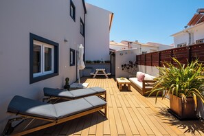 Relax in a peaceful outdoor space with a comfortable lounge area and a view of the surrounding buildings.