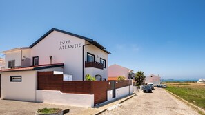Situated on a coastal property, SURF ATLANTIC offers a two-story building with a balcony and flat roof.