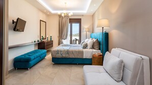 Una camera da letto moderna con un letto, una panca, un divano, una TV e una lampada.