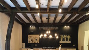 A spacious kitchen with a long wooden table, bar stools, and a black countertop.