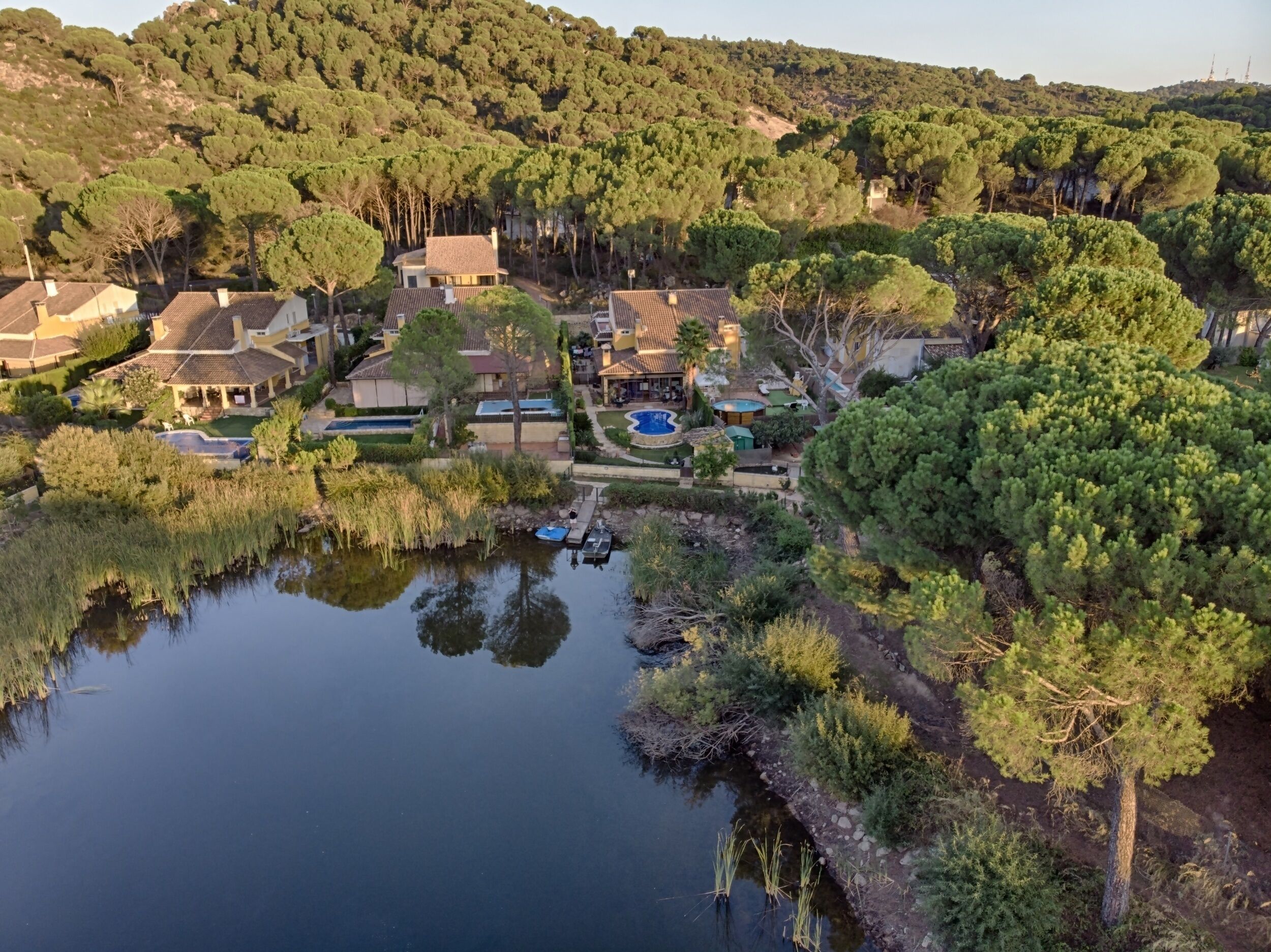 A residential area with houses, a swimming pool, and a body of water.