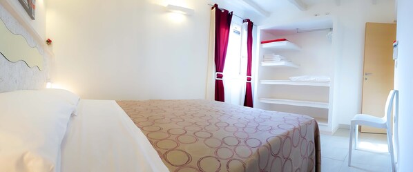 Un dormitorio con cama, armario y silla.