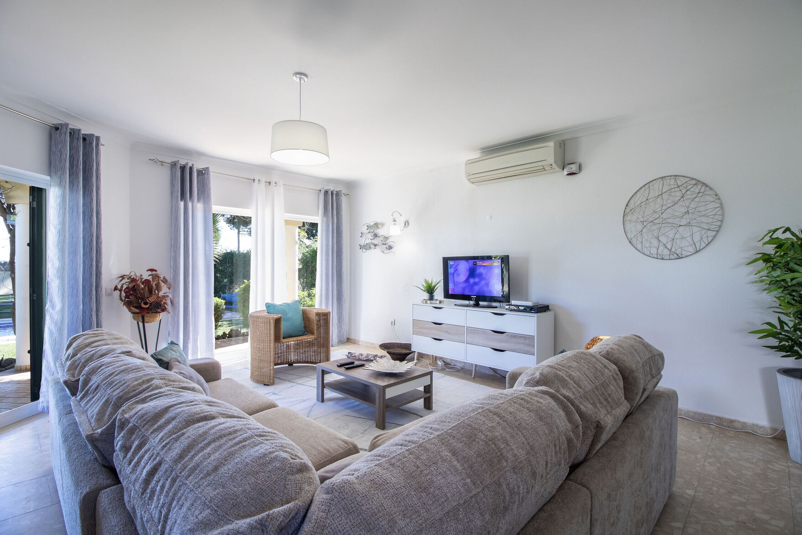 A modern living room with a sofa, coffee table, and TV.
