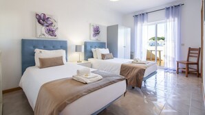 Habitación de hotel con dos camas, un comedor y vista al exterior.