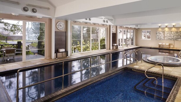 Un'ampia piscina coperta con zona soleggiata e sauna.