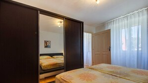 A bedroom with a bed, a wardrobe, and a door.