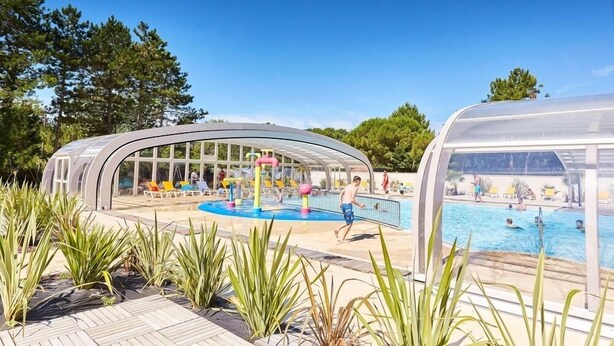 A pool area with a covered seating area and a separate pool. - Mobil-Homes Deux Chambres (Saint-Jean-de-Monts)