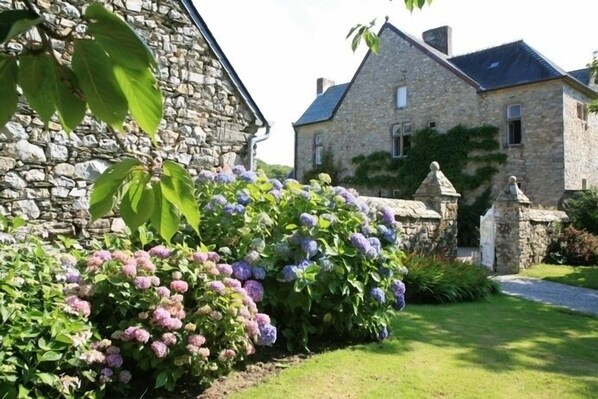 A stone building with a garden in front.