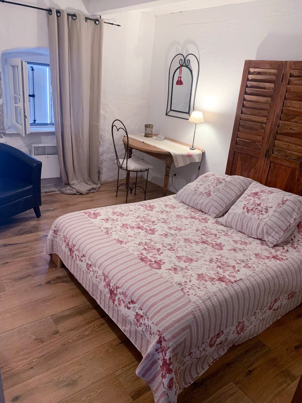 A bedroom with a bed, a desk, and a chair.