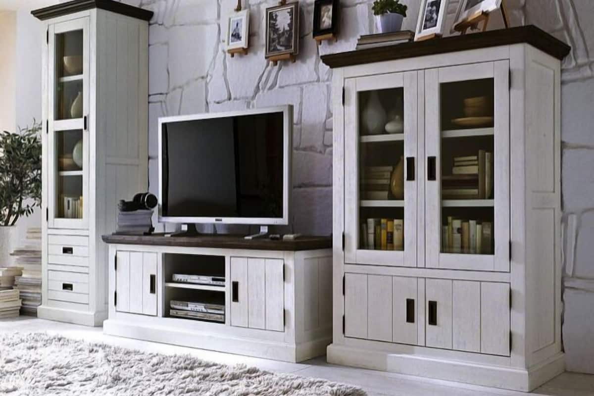 A living room with a television, cabinets, and a fireplace.