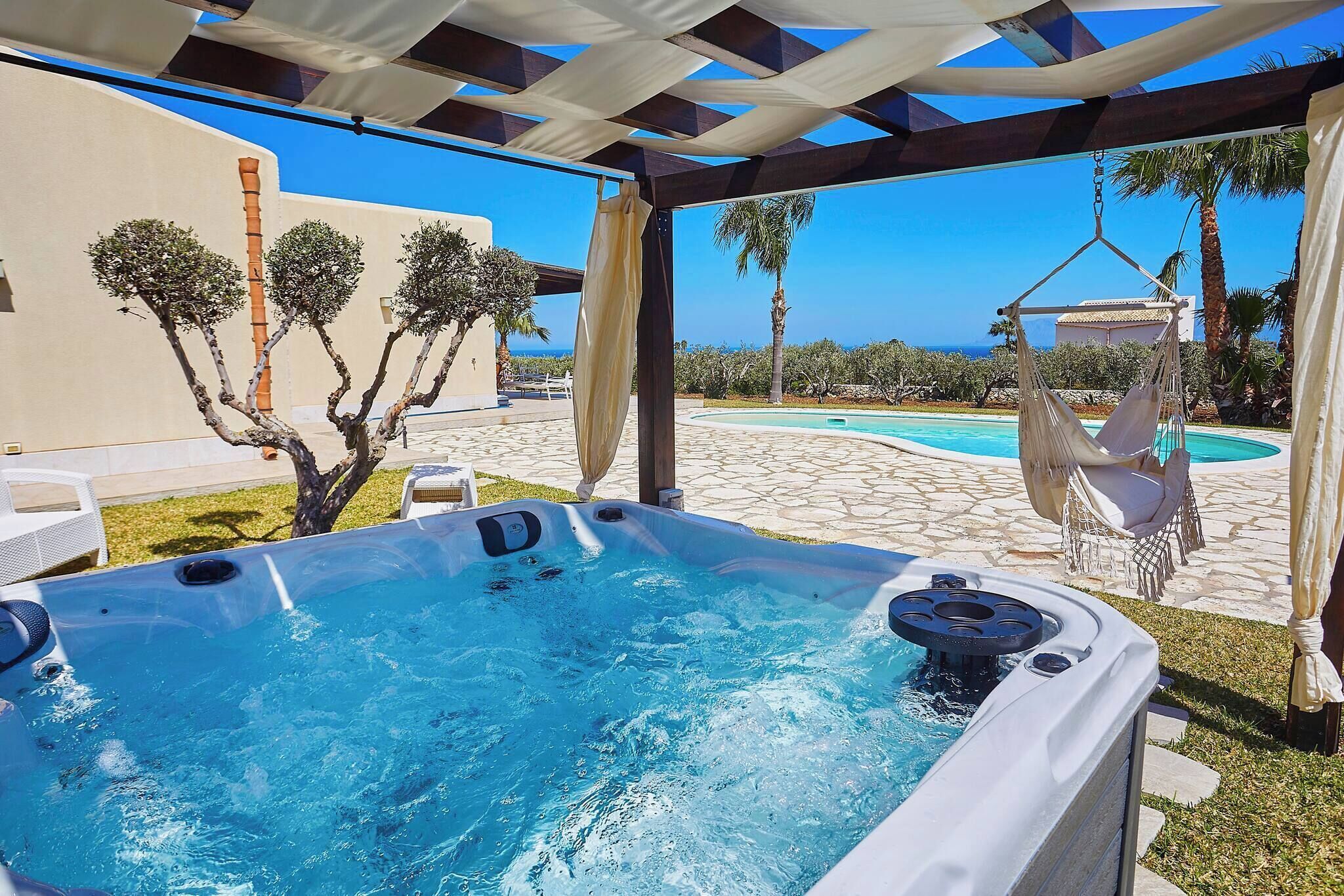 Een hottub met uitzicht op een zwembad en palmbomen.