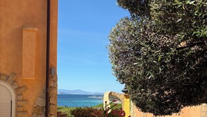 Un chemin de pierre mène à un bâtiment d’où l’on a une vue sur la mer.