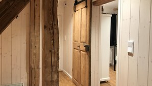 A wooden interior with a large sliding barn door, white walls, and a radiator. - Klein Bullerbü im Alpbachtal Tegernsee (Tegernsee)