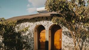 A pathway leading to a building with a stone facade and two arched doorways. - Saab Royale Resort (Ilyagaleni)