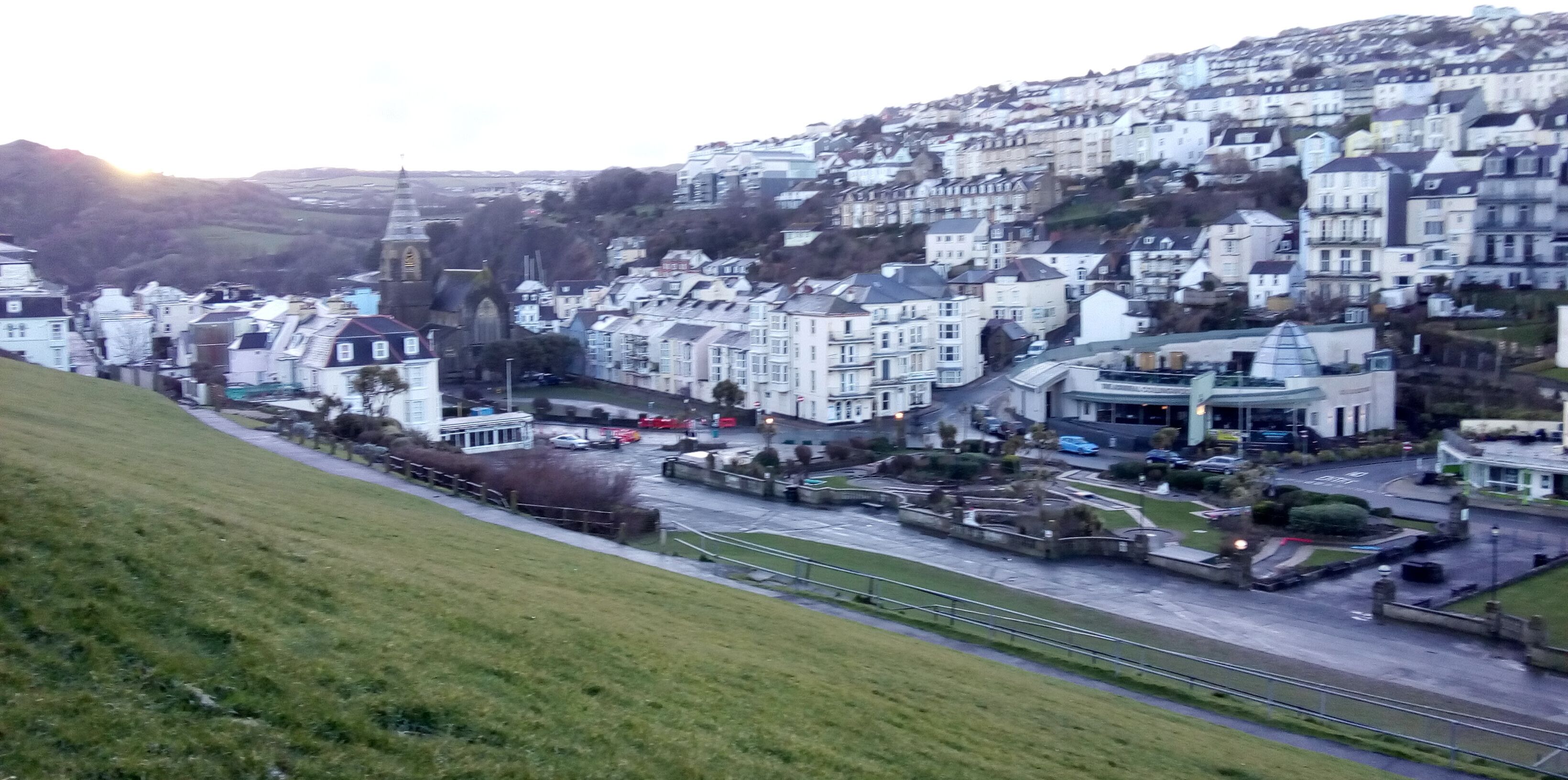 A town with historic buildings, a church, and a hill with residential houses.