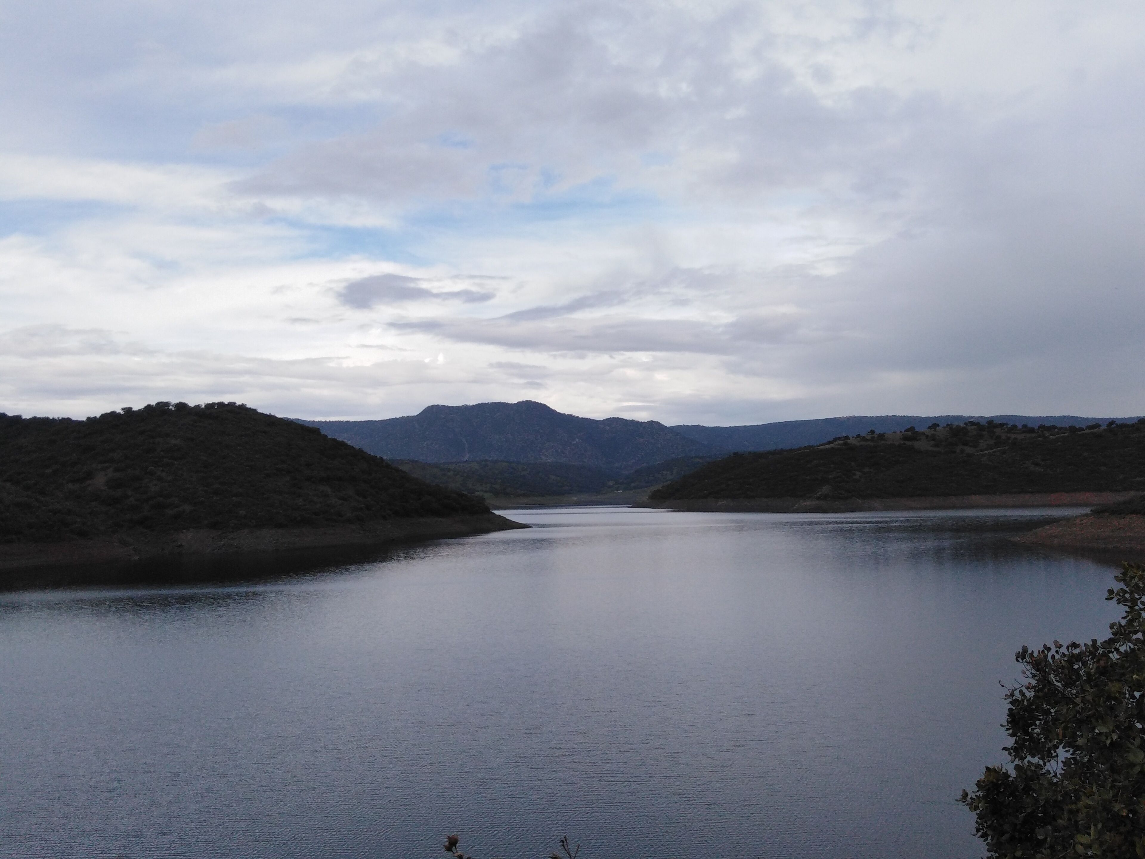 A calm lake with hills in the background.