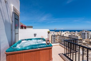 A hot tub on a balcony with a city view. - Seashells Penthouse Hot Tub Seaview by Getaways Malta (St. Paul's Bay)