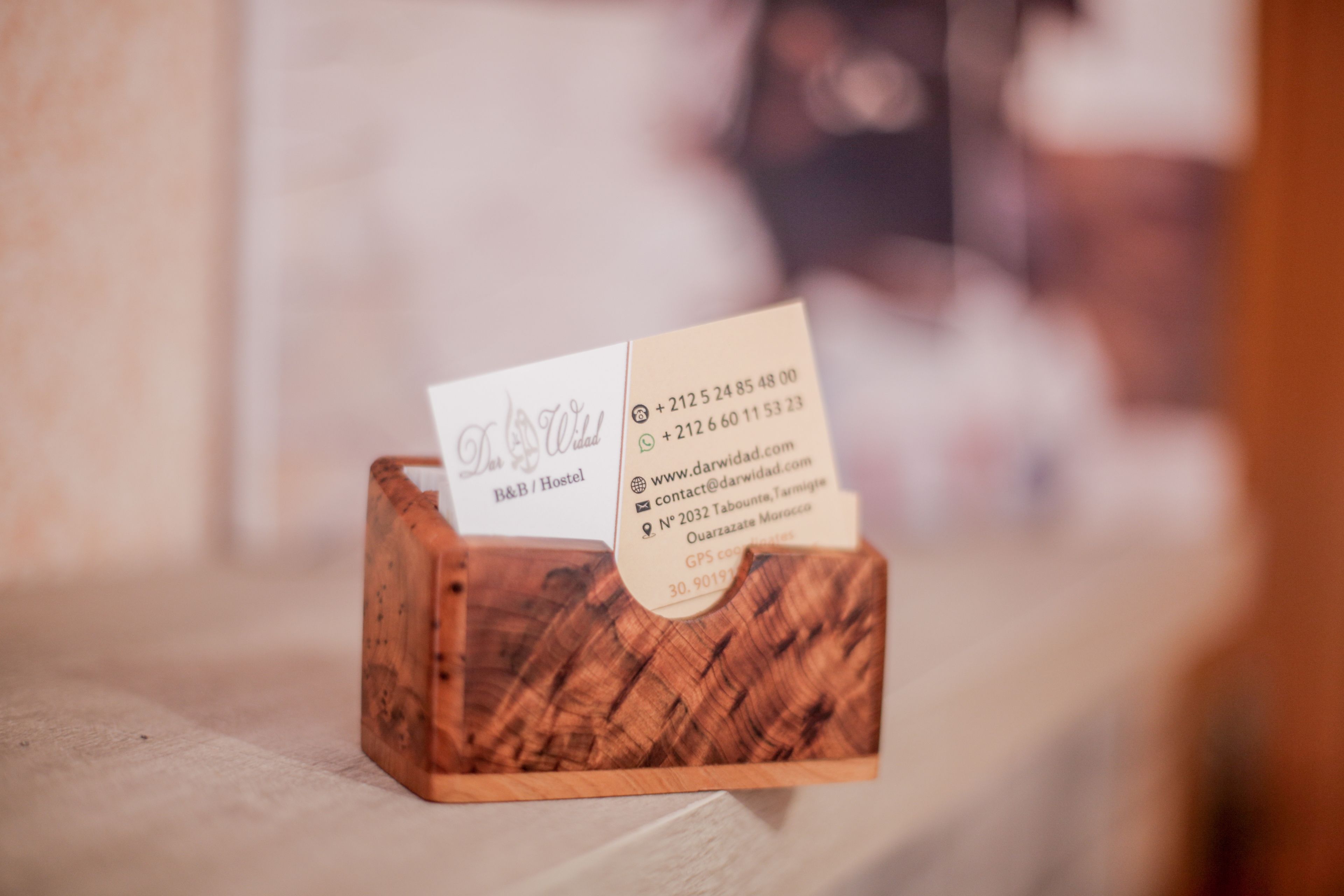 Un porte-cartes de visite en bois, avec une carte à l'intérieur.