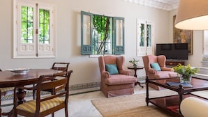 A dining area with a wooden table and chairs, a television, and a decorative vase. - San José 3 by Home at Homes (Sevilla)